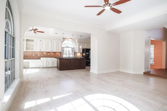 unfurnished living room with crown molding and ceiling fan