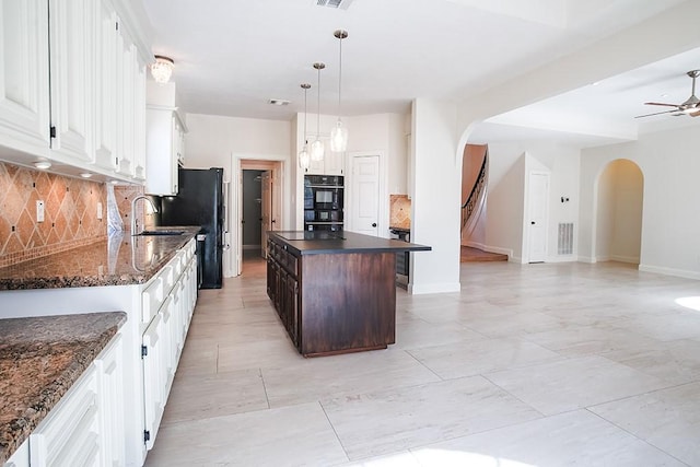 kitchen featuring sink, white cabinets, a center island, dark brown cabinetry, and black appliances