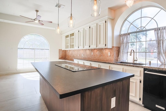 kitchen featuring sink, white cabinets, decorative backsplash, a center island, and black appliances