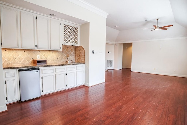 kitchen featuring white cabinetry, fridge, ornamental molding, and decorative backsplash