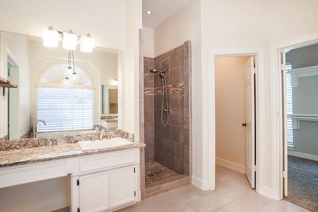 bathroom with a tile shower and vanity