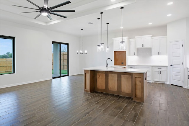 kitchen with a large island with sink, white cabinetry, plenty of natural light, and sink