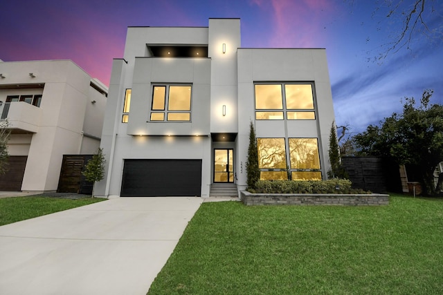 contemporary home featuring a garage and a yard