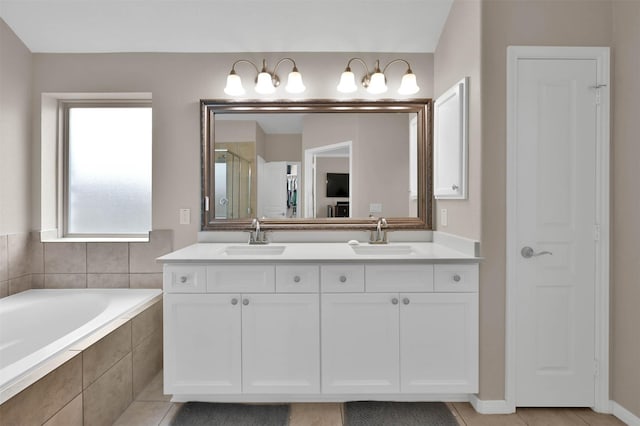 bathroom featuring vanity, tiled tub, and tile patterned flooring