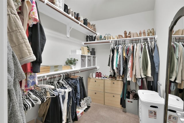 walk in closet featuring light colored carpet