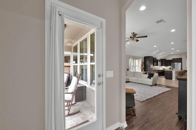 doorway featuring ceiling fan, vaulted ceiling, and dark hardwood / wood-style flooring