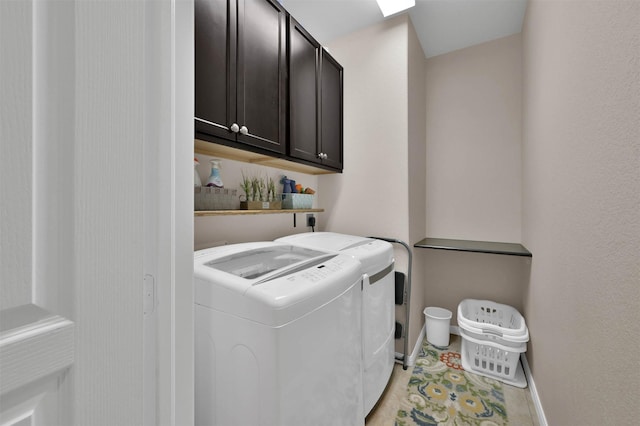 clothes washing area with cabinets and separate washer and dryer