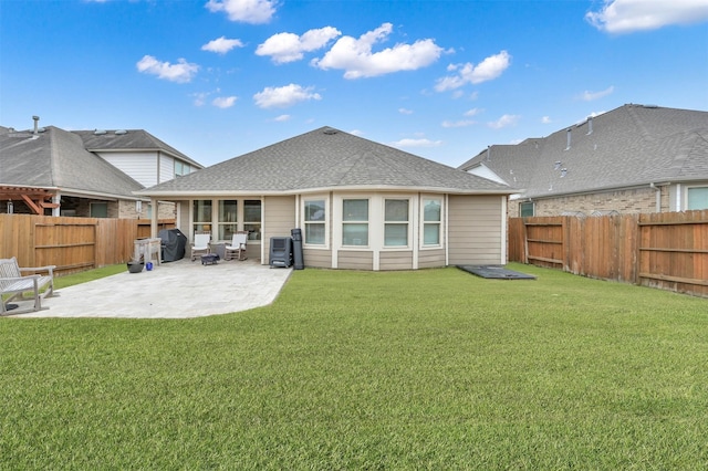 back of property with a yard and a patio area