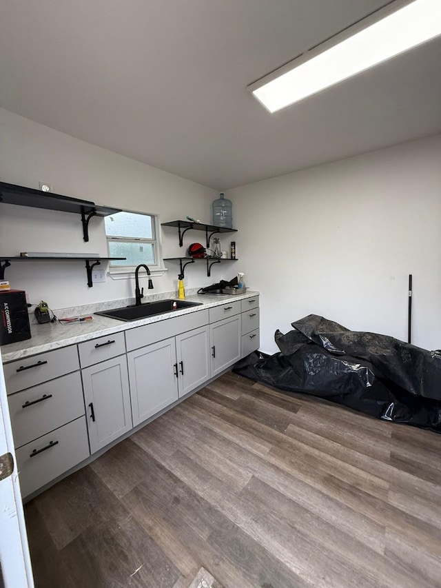 laundry room featuring sink and hardwood / wood-style floors