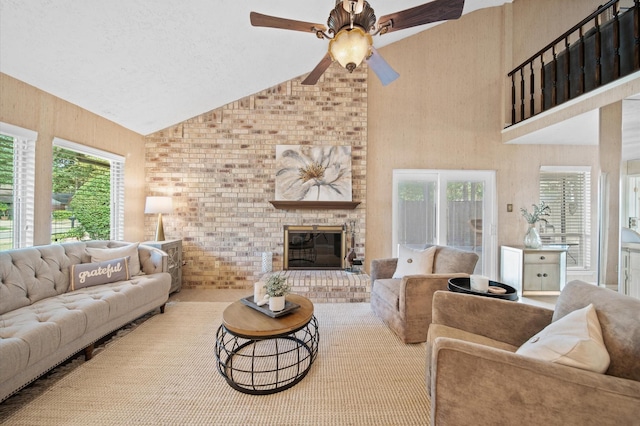 living room featuring lofted ceiling, a fireplace, a wealth of natural light, and ceiling fan