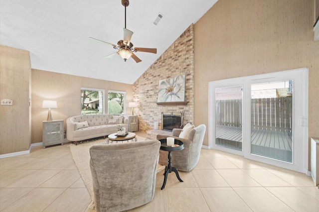 living room featuring a brick fireplace, high vaulted ceiling, ceiling fan, and light tile patterned flooring