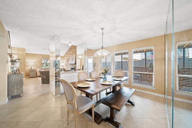 tiled dining room featuring an inviting chandelier and a textured ceiling