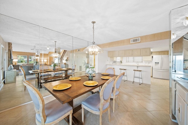 tiled dining room featuring a chandelier