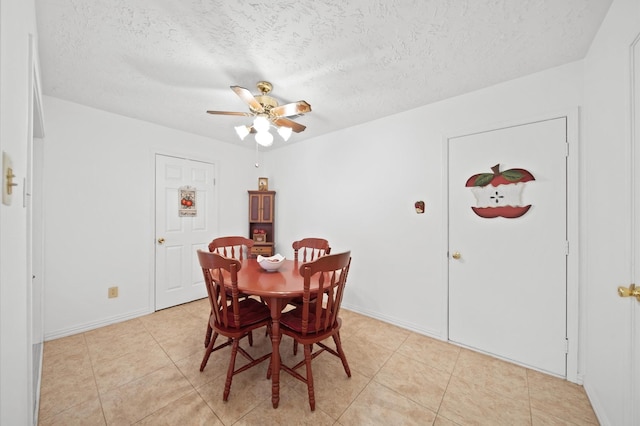 dining room featuring ceiling fan, a textured ceiling, and light tile patterned floors