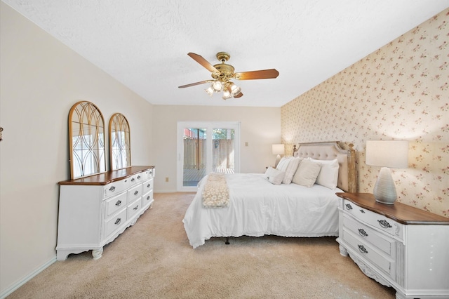 carpeted bedroom with ceiling fan, a textured ceiling, and access to outside