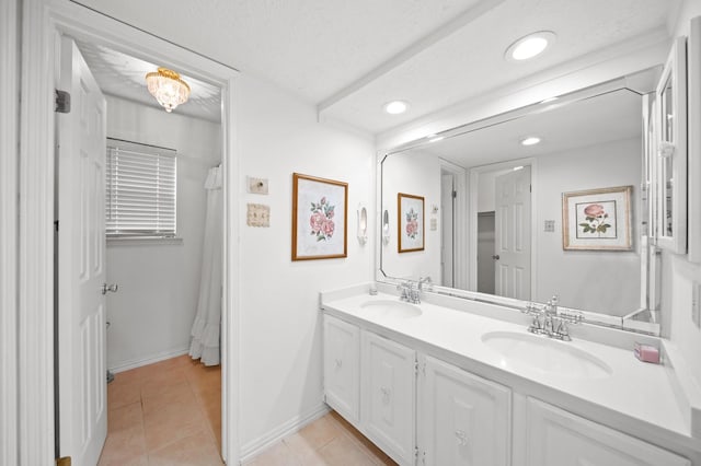 bathroom featuring vanity, tile patterned flooring, and a textured ceiling