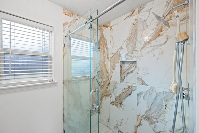 bathroom featuring an enclosed shower, a textured ceiling, and a wealth of natural light