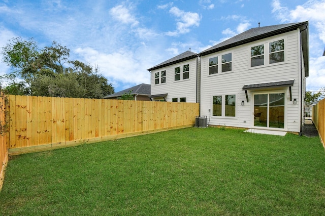 rear view of house featuring a yard and central air condition unit