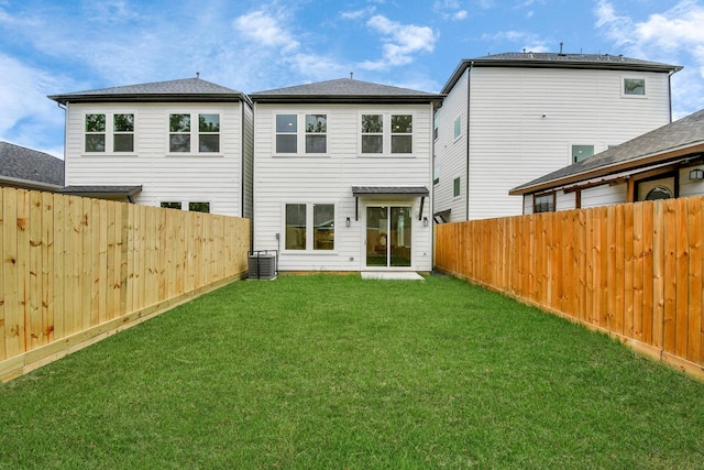 back of property featuring central AC and a lawn