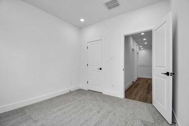 unfurnished room featuring dark carpet