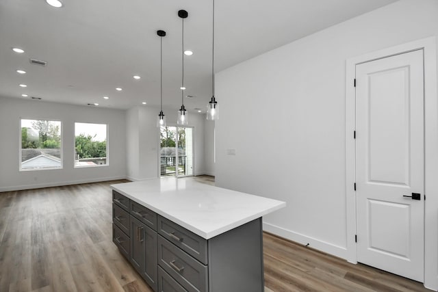 kitchen featuring hardwood / wood-style flooring, a center island, and hanging light fixtures