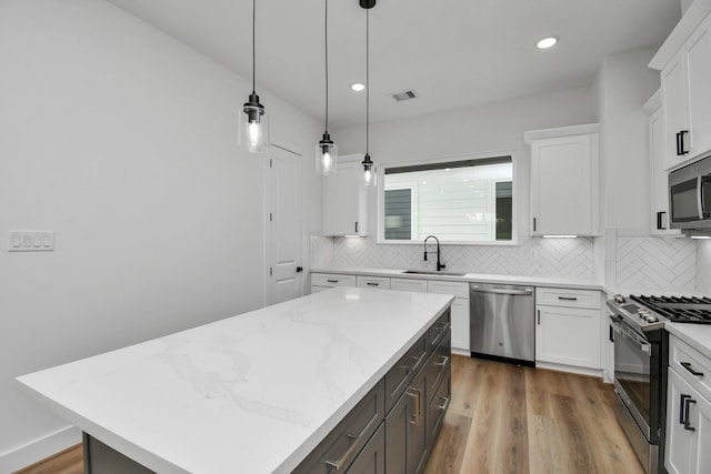 kitchen with a kitchen island, white cabinetry, and appliances with stainless steel finishes