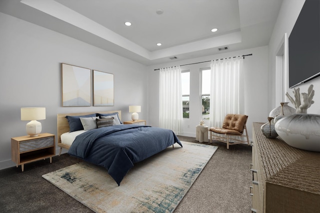 bedroom with dark carpet and a raised ceiling