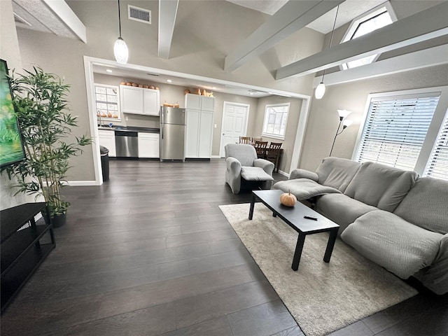 living room featuring beamed ceiling and dark hardwood / wood-style floors