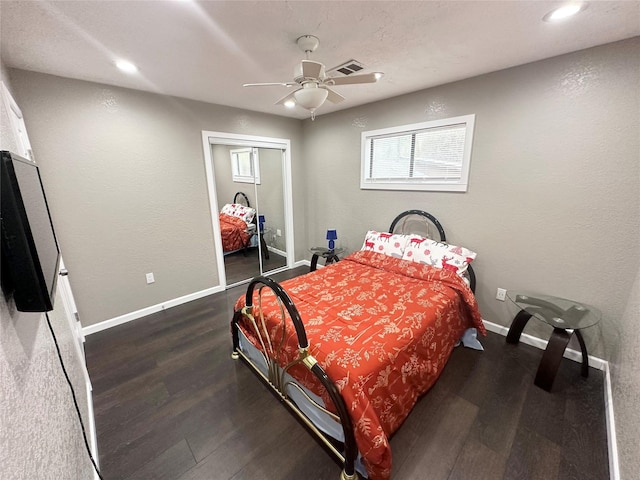 bedroom with dark wood-style floors, a closet, visible vents, and baseboards