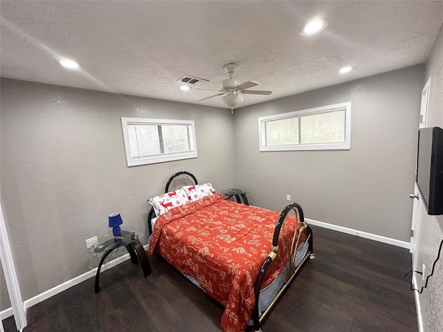 bedroom featuring dark wood-type flooring, a textured ceiling, and ceiling fan