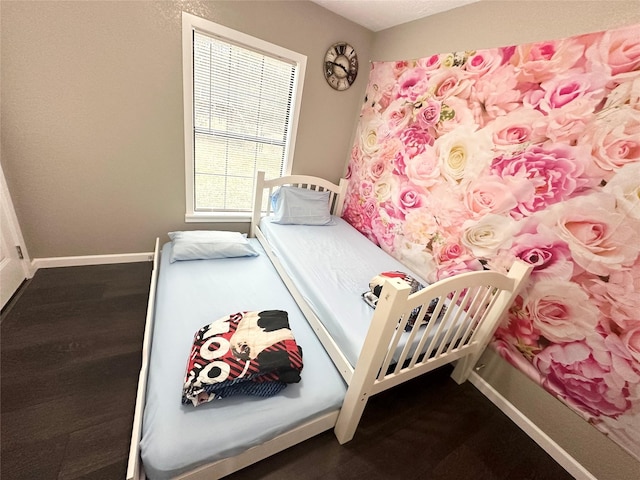 bedroom featuring baseboards and wood finished floors