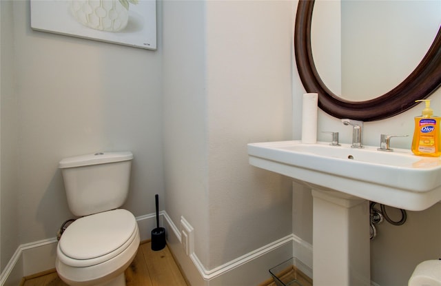 bathroom featuring hardwood / wood-style flooring and toilet