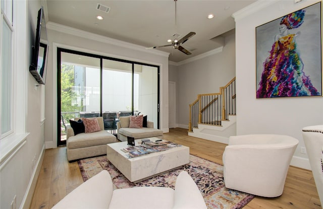 living room with ornamental molding, ceiling fan, and light hardwood / wood-style flooring