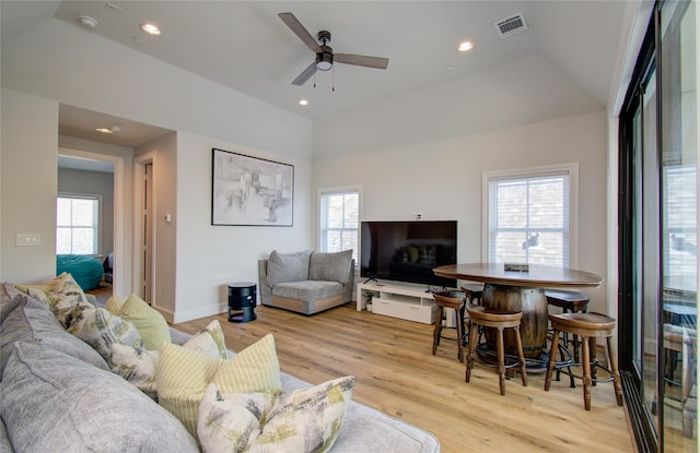 living room featuring lofted ceiling, ceiling fan, light hardwood / wood-style floors, and a healthy amount of sunlight