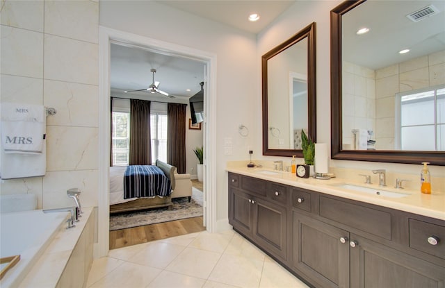 bathroom with tile patterned floors, vanity, and tiled tub