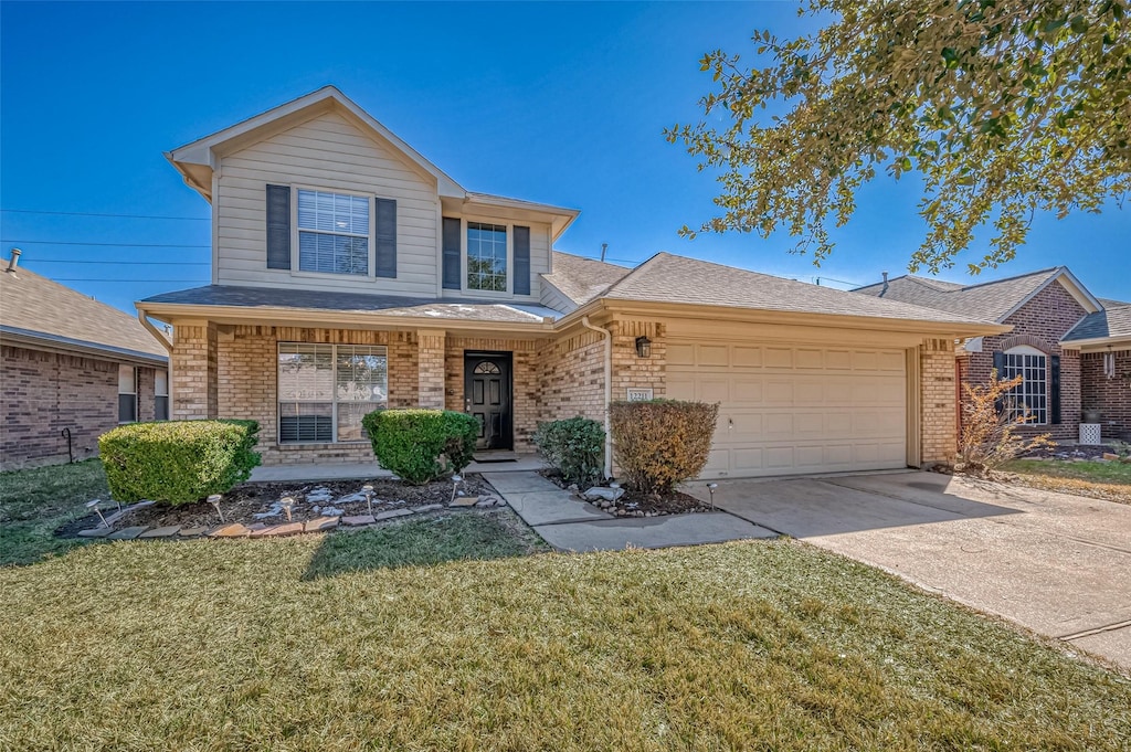 front of property with a garage, a front lawn, and covered porch