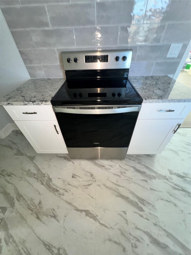 kitchen with white cabinetry, light stone counters, stainless steel range with electric cooktop, and decorative backsplash