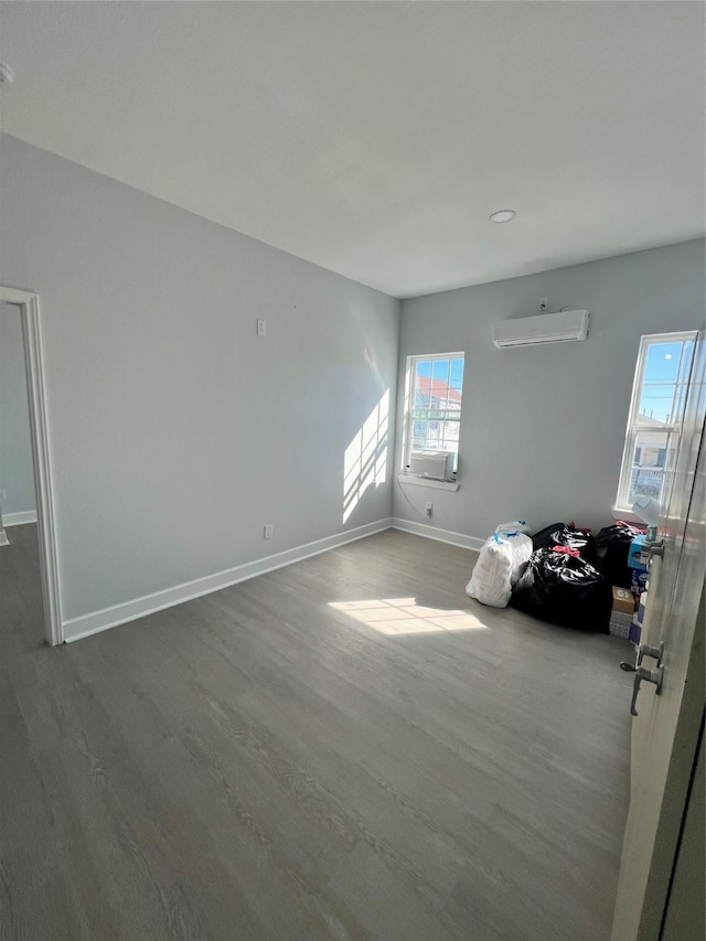 interior space with cooling unit, hardwood / wood-style floors, and an AC wall unit