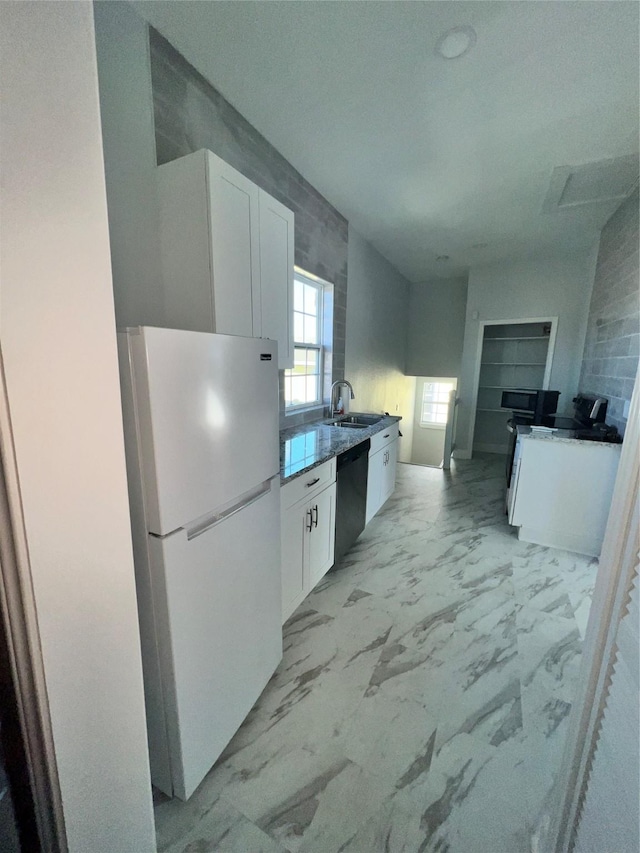 kitchen featuring white refrigerator, white cabinetry, black dishwasher, and sink