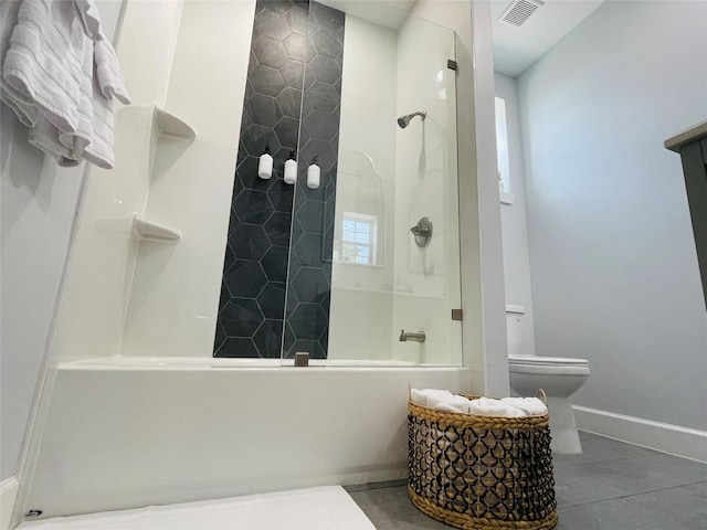 bathroom featuring a shower with door, tile patterned flooring, and toilet