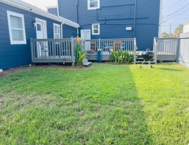 back of house with a deck and a lawn