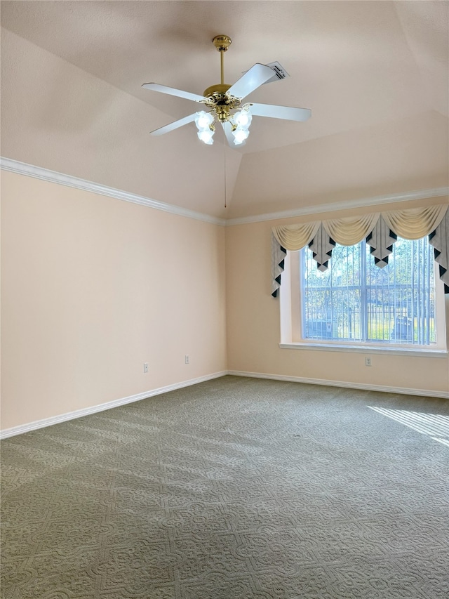 carpeted spare room with ornamental molding, vaulted ceiling, and ceiling fan