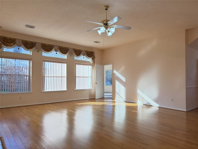 empty room featuring ceiling fan, a textured ceiling, and light wood-type flooring