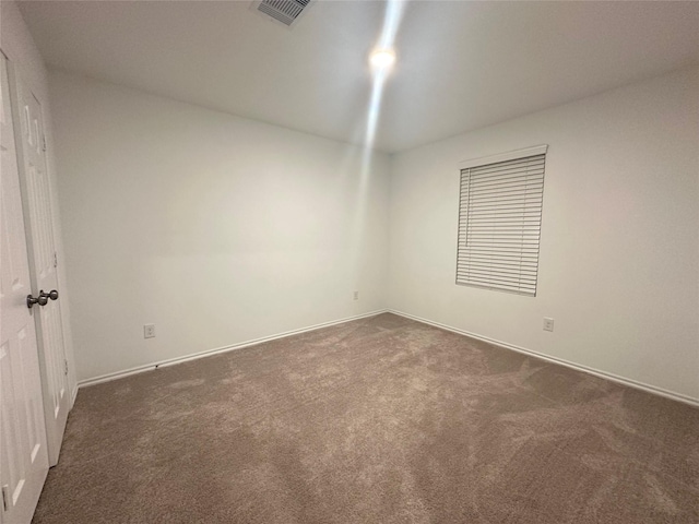 empty room with dark colored carpet