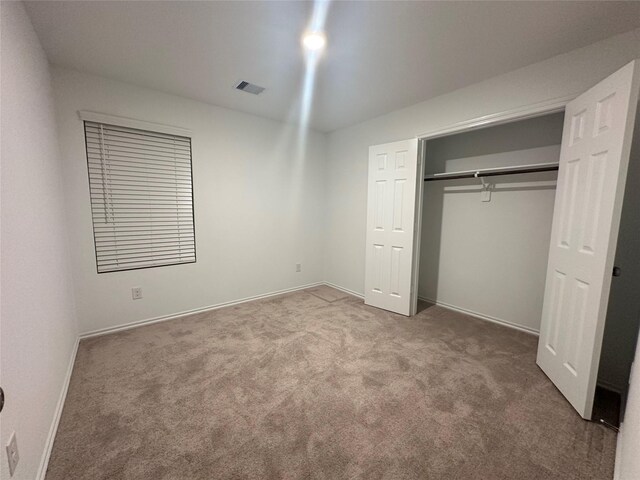 unfurnished bedroom with carpet flooring and a closet