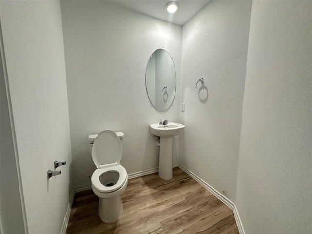 bathroom featuring sink, hardwood / wood-style floors, and toilet