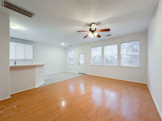 unfurnished living room featuring ceiling fan and light hardwood / wood-style flooring