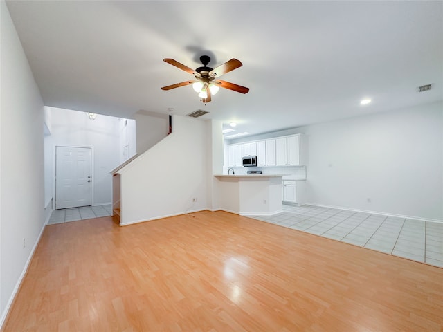 unfurnished living room with ceiling fan and light wood-type flooring