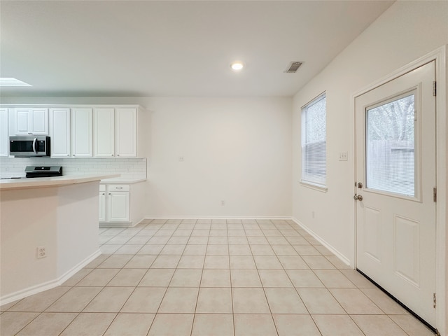 kitchen with white cabinetry, tasteful backsplash, stainless steel appliances, and light tile patterned flooring