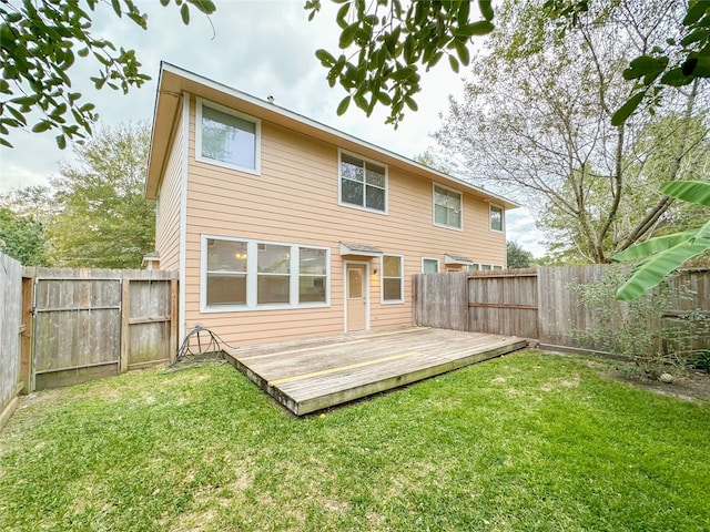 back of house featuring a wooden deck and a yard